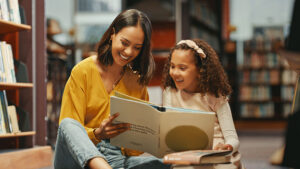parent reading a book with her daughter
