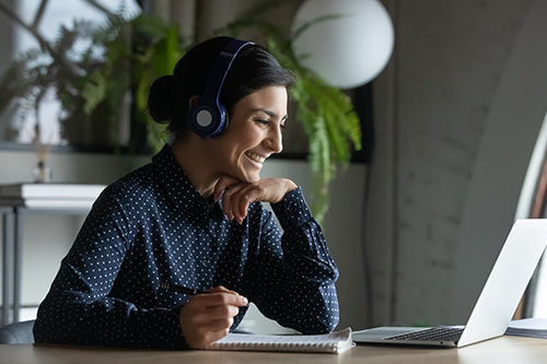 Woman using laptop with headphones