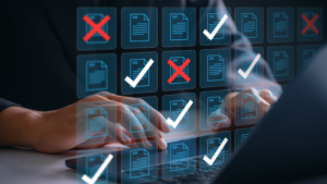 Person using a laptop with digital documents marked with checkmarks and Xs.