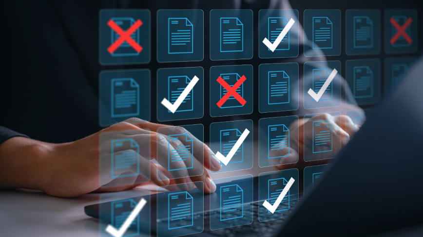 Person using a laptop with digital documents marked with checkmarks and Xs.
